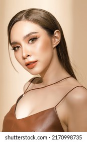 High fashion of perfect slim body beautiful face young elegant woman in latex dress on isolated beige background. Portrait of female model in studio. plastic surgery and aesthetic cosmetology.