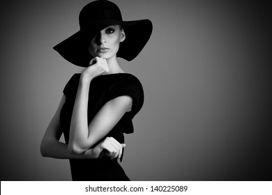 High Fashion Portrait Of Elegant Woman In Black And White Hat And Dress. Studio Shot