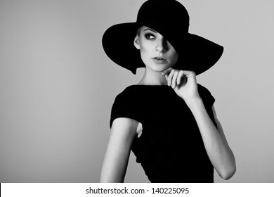 High Fashion Portrait Of Elegant Woman In Black And White Hat And Dress. Studio Shot