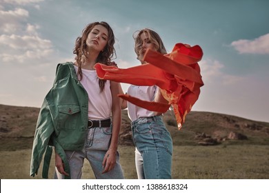 High fashion portrait of two stylish beautiful woman in trendy jackets and jeans posing outdoor. . 