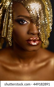 High Fashion Portrait Of Young African American Female Model With Gold Glossy Makeup And Hairstyle. Face Art.