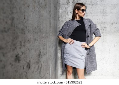 High Fashion Portrait Of Young Elegant Woman Outdoor. Grey Ã?Â�oat, Cat Eye Sunglasses, Grey Wall Background