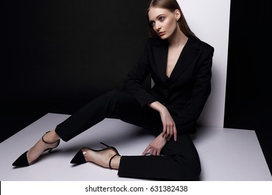 High Fashion Portrait Of Young Elegant Woman In Black Suit. Studio Shot.