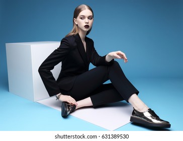 High Fashion Portrait Of Young Elegant Woman In Black Suit And Loafers. Studio Shot.