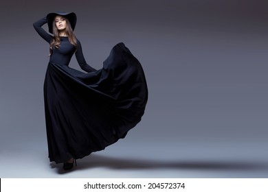 High Fashion Shot Of Elegant Woman In A Hat And Long Fluttering Dress.  