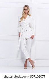 High Fashion Shot Of Young Blond Woman In White Suit On White Background.