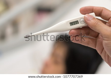 High fever or hyperpyrexia concept. Thermometer with temperature 41.1°C Centigrade with blur background of child sleep on hospital bed