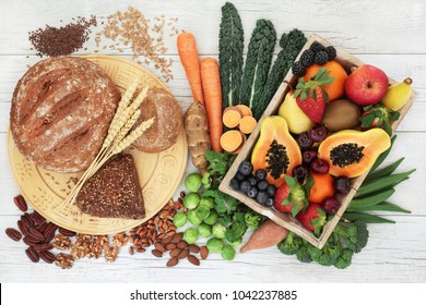 High fibre healthy food concept with wholegrain bread and rolls, nuts, seeds, fruit, vegetables and grains with foods high in antioxidants, omega 3 fatty acids, anthocyanins and vitamins.  Top view.