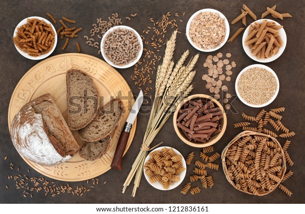 High fibre natural health food with whole\
wheat pasta, whole grain rye bread, oatmeal, oats, bran flakes and\
wheat sheath on lokta paper background. \
