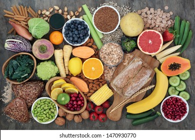 High fibre super food with whole grain bread loaf and rolls, fruit, vegetables, whole wheat pasta, cereals, seeds and nuts. Foods omega 3, anthocyanins, antioxidants and vitamins. Top view.