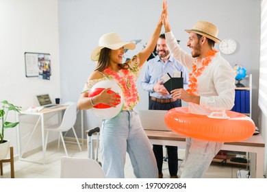 High Five, Partner! Boyfriend And Girlfriend Giving A High Five And Celebrating After Receiving Their Plane Tickets For Their Summer Vacations From The Travel Agent 