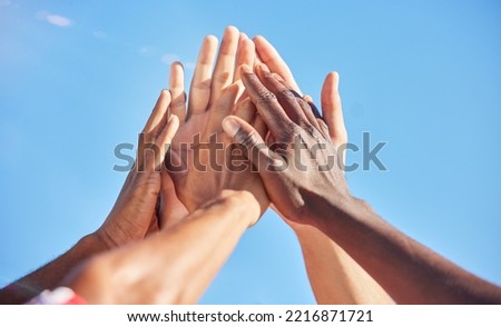 High five, sports and team with support, motivation and solidarity during a game with a blue sky. Group of people, athlete friends or men with hands together for a win, success and partnership