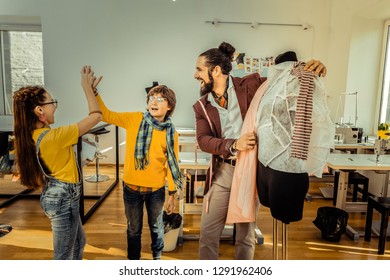 High five. Talented creative children giving high five to each other after successful work in atelier - Powered by Shutterstock