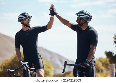 High five, winner and cycling team of cyclists having fun riding together outdoors in nature. Happy, excited and fit male bicycle riders on a break after exercising and training in the environment - Powered by Shutterstock