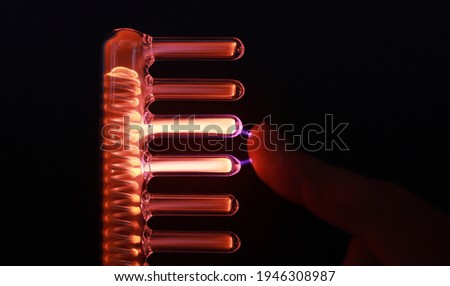 High frequency current produced by Comb tube of High Frequency D'arsonval Device. Electricity concept. Hair micro current therapy. Hair care, hair loss. High frequency electrotherapy, beauty tool
