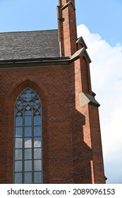 High Gothic Window With Colored Stained Glass Filling In Red Brick Masonry