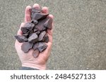 High grade (more than 63% Fe content) Australian iron ore, hematite (Fe2O3) held in hand. Blast furnaces feed for iron-making.