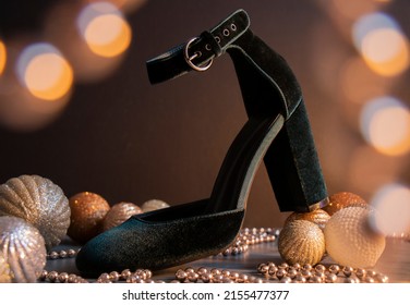 High heeled shoe in the centre of the frame with bokeh effect in the foreground and baubles and glitter around the heel. 