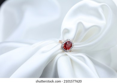 High jewelry banner with color natural gemstone as Patparadcha as Ruby and diamonds on gold ring setting. White satin with tray background for jewelry shop