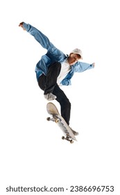 High jump. Active young man in casual clothes in motion, riding skateboard, training isolated over white background. Concept of professional sport, competition, training, action. Copy space for ad