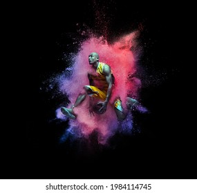 High jumping. Young man, male basketball player in explosion of colored neon pink powder isolated on black background. Concept of energy, power, motion. Copyspace for ad, design. Splashing of bright