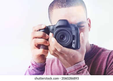 High Key Portrait Of A Black Male Photographer With Camera Focusing On The Viewer In A Cropped Close Up