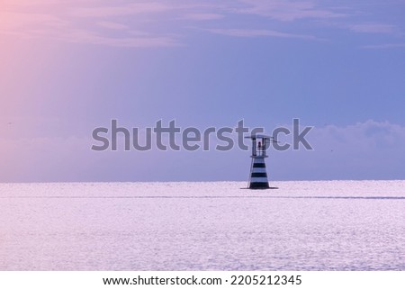 high lighthouse tower white and red color near sea shore port. construction building for navigator and signal safety. calm place for vacation sunrise 