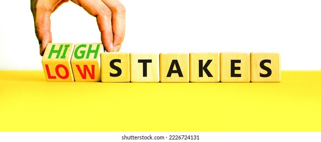 High or low stakes symbol. Concept words High stakes and Low stakes on wooden cubes. Businessman hand. Beautiful yellow table white background. Business high or low stakes concept. Copy space. - Shutterstock ID 2226724131