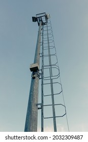 High mast of spot light with ladder on evening blue sky background