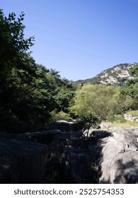 A high mountain is visible beyond the deep rocky valley.