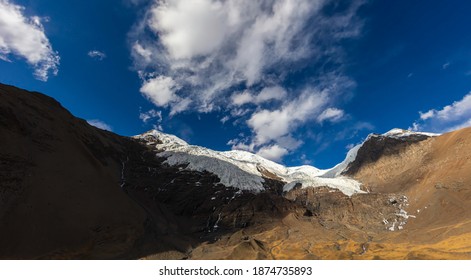 Hoch oben in den Bergen von Tibet, China. Der Kangbu-Gletscher auf 5200 Meter Höhe. Weiße Wolken und blauer Himalaya über dem Schnee auf dem Gipfel des Berges im Himalayas
