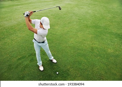 High Overhead Angle View Of Golfer Hitting Golf Ball On Fairway Green Grass