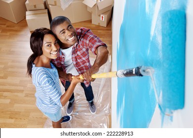 High Overhead View Of Young Black Couple Painting Wall With Roller In New House