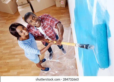 High Overhead View Of Young Black Couple Painting Wall With Roller In New House