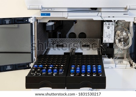 High performance liquid chromatography (HPLC) sample vial application for analysis some chemicals. The researcher placing the vial samples into the HPLC rack for auto-injection in chemistry laboratory