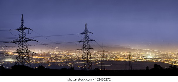 High power electricity poles in urban area. Energy supply, distribution of energy, transmitting energy, energy transmission, high voltage supply concept photo.
