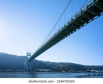 High powerful arch support of a gothic style long transport St Johns Bridge with windows at the top and stretch marks that support the bridge across Willamette River in Portland industrial area