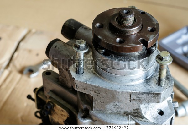 High pressure diesel\
fuel pump. Drive shaft with a pulley of the fuel pump. Car service.\
Selective focus.
