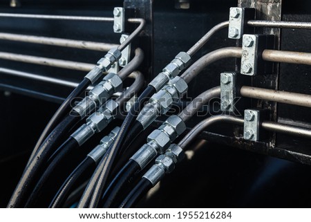 High pressure hydraulic hose system connected to steel pipes, close-up. Marine hydraulics.