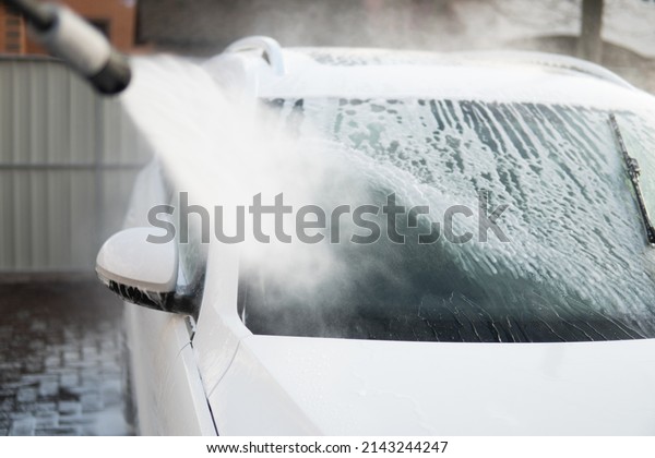 High Pressure Water. Cleaning Car Using Washing\
with soap. Manual car wash outside. Manual car wash with white\
soap, foam on the body. Close\
up.