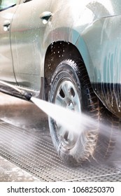 High Pressure Water Stream Washing A Car At Handwash Car Station. Vertical Close Up Crop