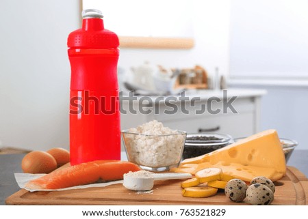 High protein food, powder and shake on table