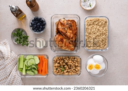 High protein healthy lunch meal prep in containers with chicken, quinoa, herbed chickpeas, vegetables and boiled eggs