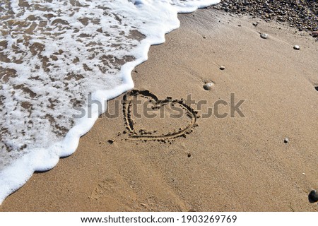 High quality image. Image of a beach with a heart drawn in the sand. Image of love.