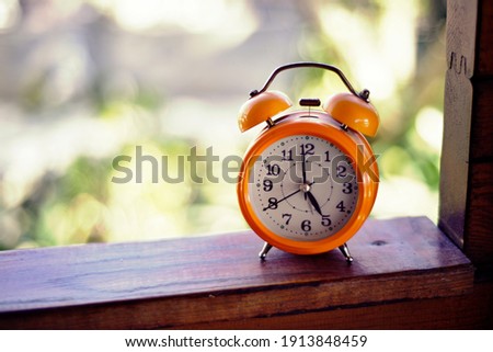 High quality image. Photograph of an orange antique clock. Image to use as a background.