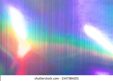 high res full frame macro photo of abstract pastel iridescent holographic foil background with light leaks. holo color wrinkled material. cool glitter surface with shiny rainbow feel. 