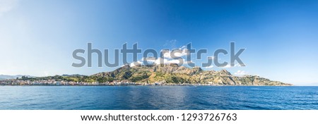 High res panoramic shot of the beautiful Giardini Naxos bay with mountains in the background near Taormina, on Sicily, Italy