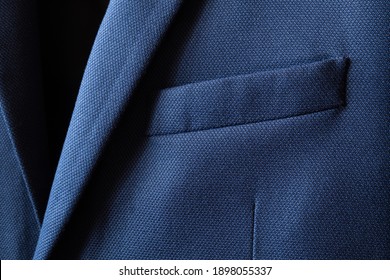 High Resolution With Details And Quality Shot Of Formal Dark Blue Wool Suit Fabric Texture. With Front Pocket Decoration Under Light And Shadow Ambient. Ideal For Background Or Wallpaper.