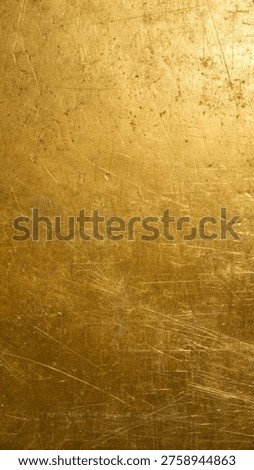 high resolution macro close up view of a distressed and scratched golden metal surface texture
