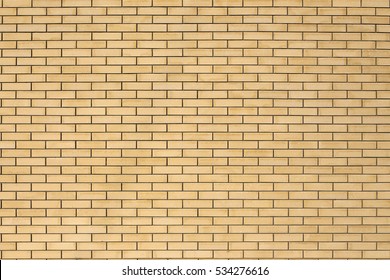 High resolution texture of a yellow brick wall background in the countryside, rough blocks of stone, brick masonry horizontal color technology architecture wallpaper.